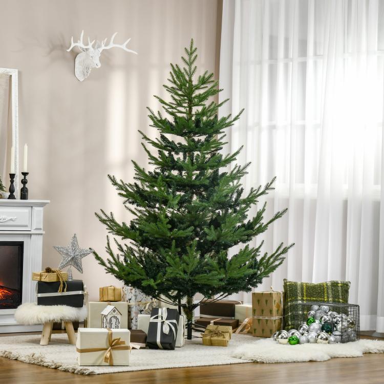 Green artificial Christmas pine tree on a black metal stand, undecorated