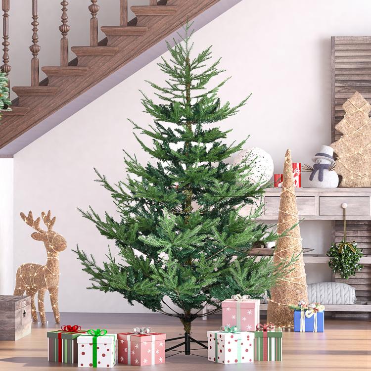 Green artificial Christmas pine tree with hinged branches on a black metal stand