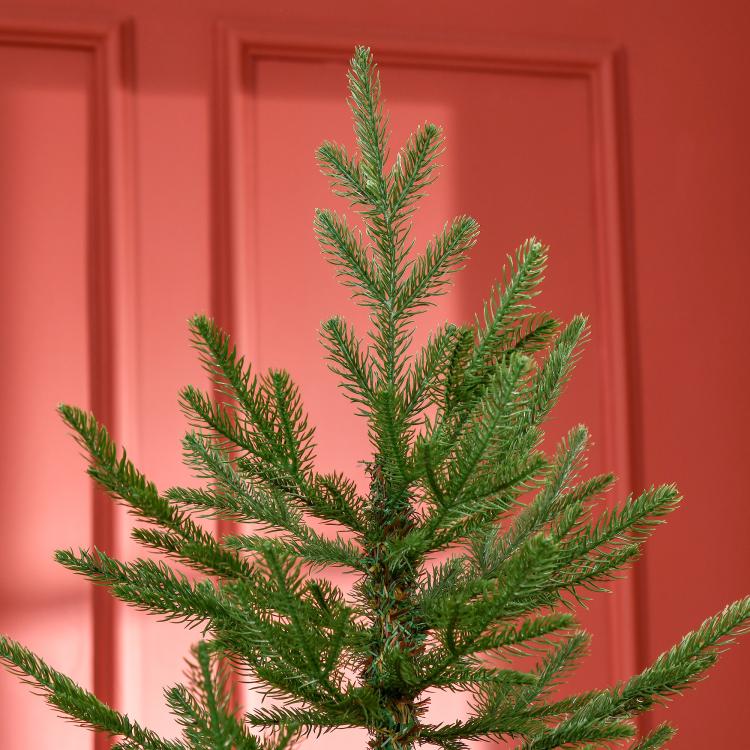 Close-up of a green artificial Christmas pine tree with layered hinged branches