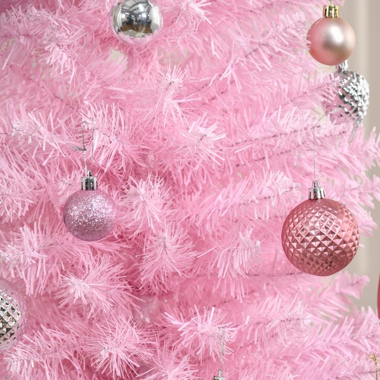 Pink artificial pencil Christmas tree with glittery ornaments and dense branches
