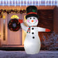 Inflatable snowman with black top hat and orange nose, wearing a green striped scarf