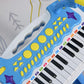 Close-up of blue toy keyboard piano keys and colorful sound-control buttons