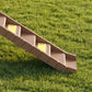 Brown foldable dog ramp with stepped platform and grip ledges, shown side view