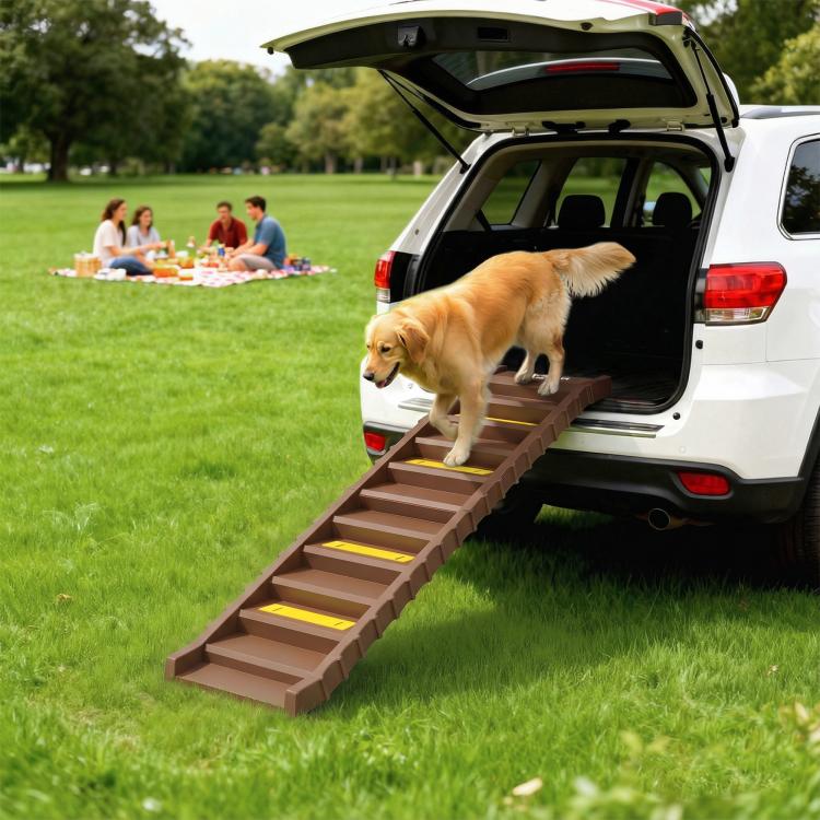 Brown foldable dog ramp used at a car rear hatch, featuring yellow non-slip step strips