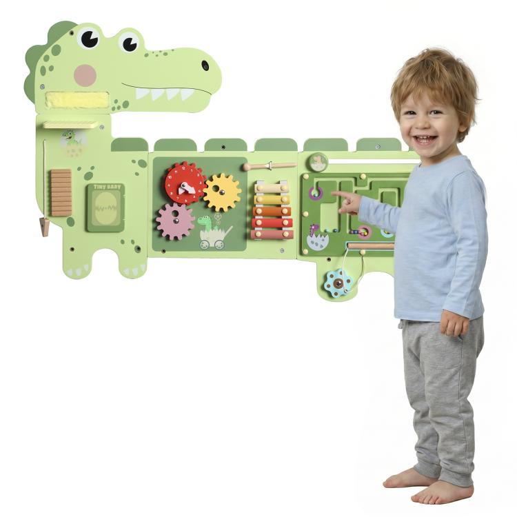 Green dinosaur Montessori busy board with gears, sliders, and maze panels on wall