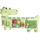 Dinosaur-shaped Montessori busy board panel with gears, xylophone bars, and switches.