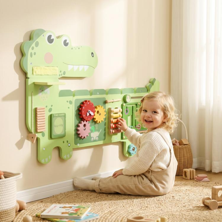Green dinosaur sensory busy board mounted on wall with interactive activity panels for kids