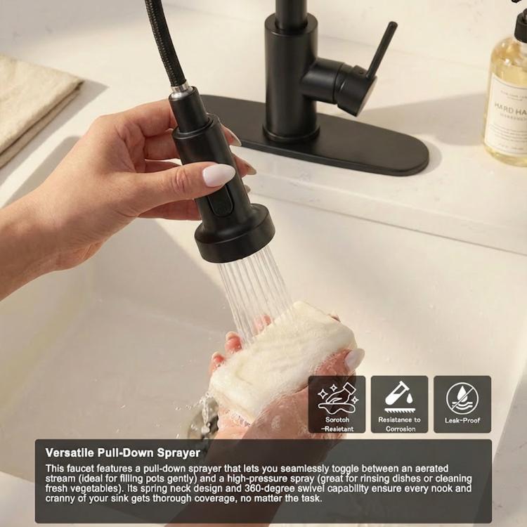 Hand holding pull-down sprayer nozzle releasing a strong stream from matte black faucet.