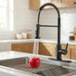Close view of matte black faucet pouring water into stainless steel sink.