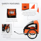 Orange and black child bike trailer with 5-point harness, flag, and inflatable wheels