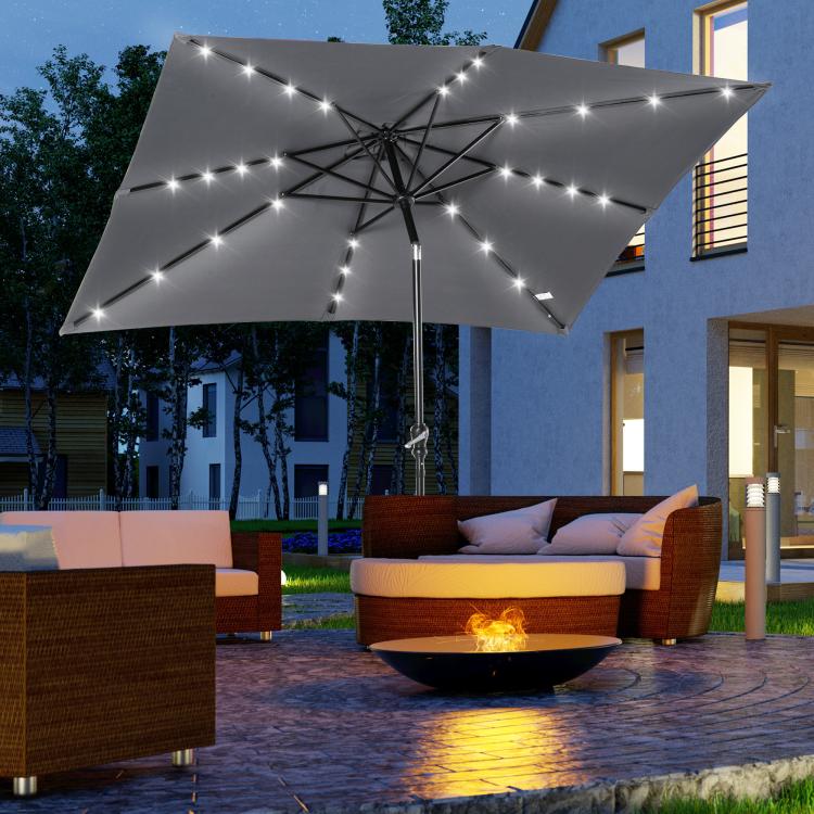Solar LED patio umbrella with gray canopy above outdoor seating and fire pit