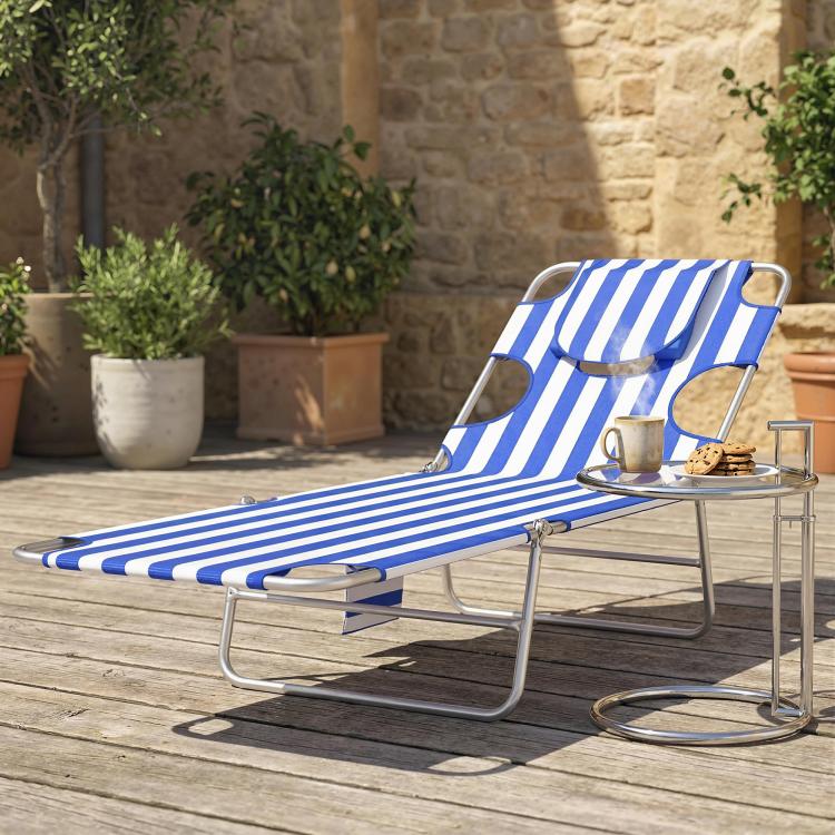 Blue striped tanning lounge chair on patio with face pillow and curved metal arms