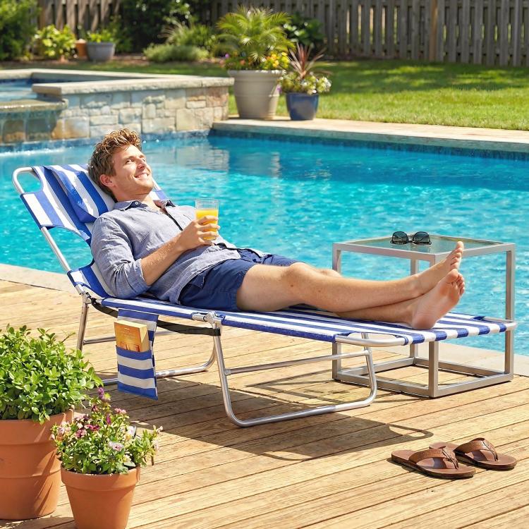 Blue striped outdoor chaise lounge chair with face pillow and steel frame, reclining