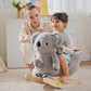 Gray plush koala rocking horse with wooden base, child seated on rocker