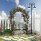 Black metal climbing arbor bench with arched trellis, decorated with pink flowering vines