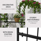 Black metal arbor bench with trellis top, leafy vines and hanging flower baskets