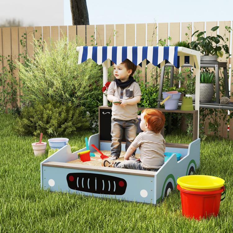 Blue kids wooden sandbox with striped canopy and bench seats, with toy sand tools
