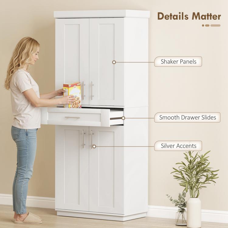 White pantry cabinet detail view with shaker doors, smooth drawer slides, and accents