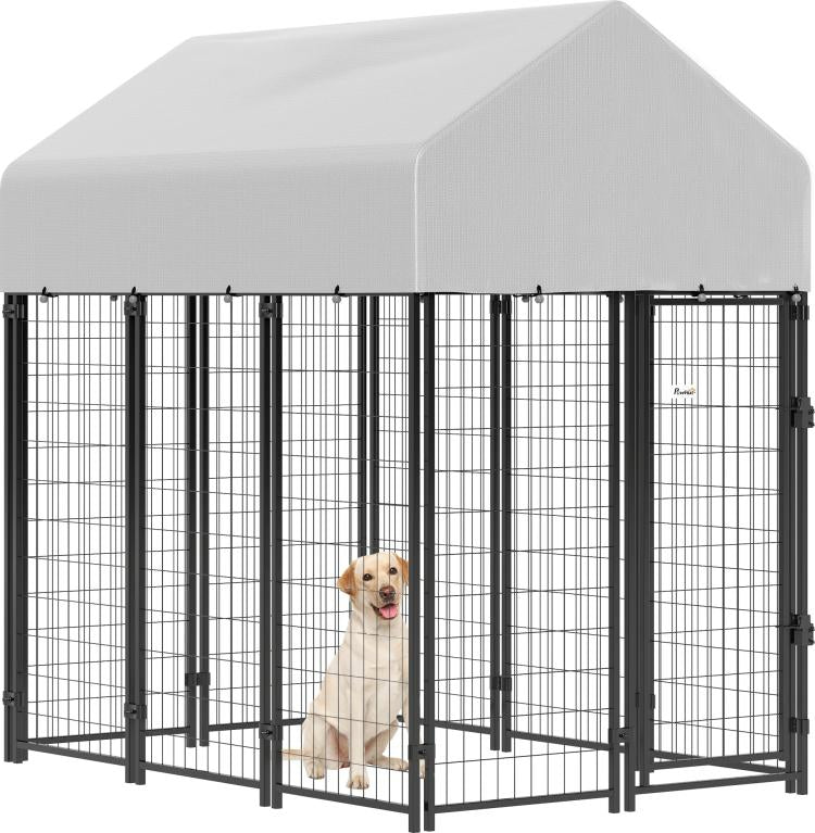 Outdoor dog kennel with peaked roof, gray cover, black welded wire walls, front door.