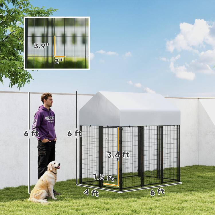 Outdoor dog kennel with peaked roof, black welded wire frame, size view with person.