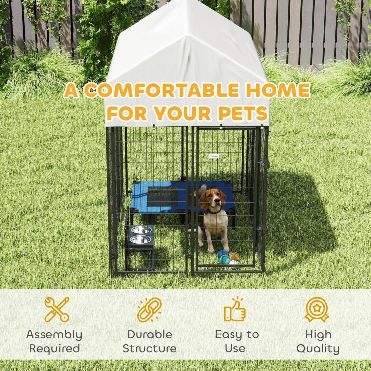 Outdoor dog kennel with peaked roof, black wire walls, small dog bed and chew toy.