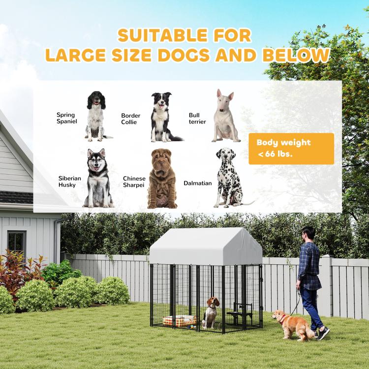 Outdoor dog kennel with peaked roof, black welded wire panels, two dogs near entrance.