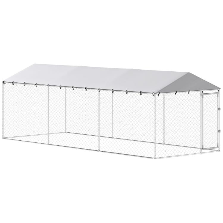 Outdoor dog kennel with silver wire mesh walls and gray roof; enclosed rectangular design