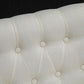 Close-up of cream button-tufted loveseat backrest upholstery