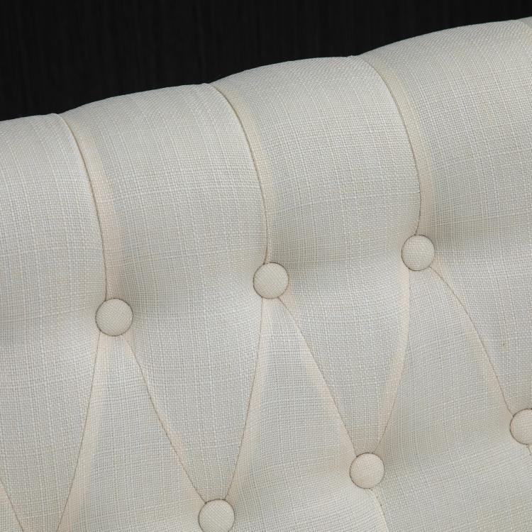 Close-up of cream button-tufted loveseat backrest upholstery
