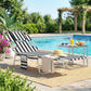Outdoor tanning chaise lounge with black-and-white stripes, face hole, and cushioned head pillow