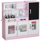 Pink kids play kitchen with microwave, stovetop, sink, and oven doors with knobs and handle.