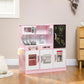 Pink kids play kitchen with stovetop, sink faucet, and black chalkboard door panel