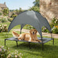 Elevated dog cot with canopy over gray mesh sleeping pad on a sturdy frame