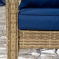 Rattan wicker patio chair with dark blue cushion; woven seat and arm detail