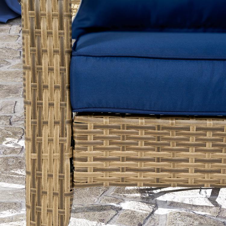 Rattan wicker patio chair with dark blue cushion; woven seat and arm detail