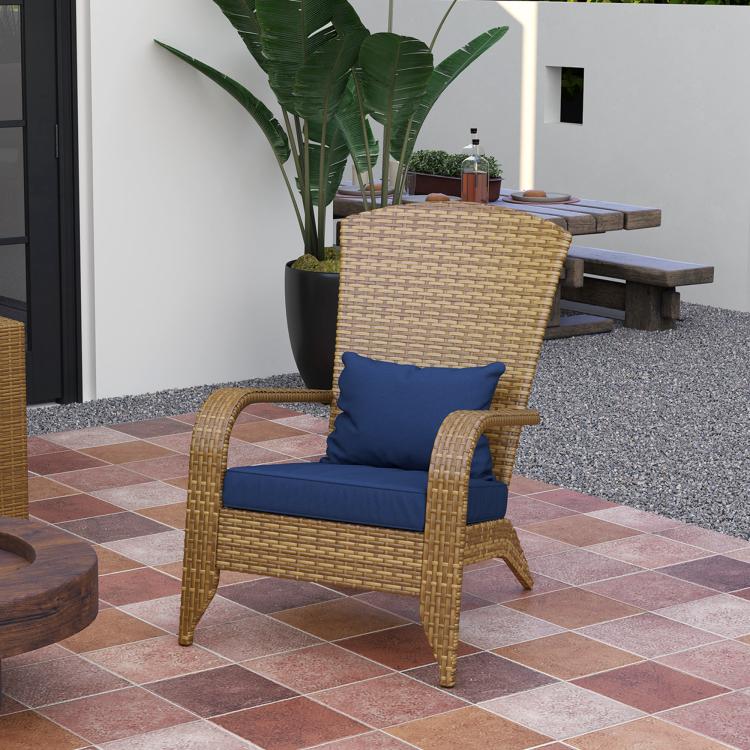 Rattan wicker outdoor chair with dark blue cushion and backrest on patio tiles