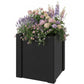 Black raised garden bed planter box filled with blooming flowers and green foliage