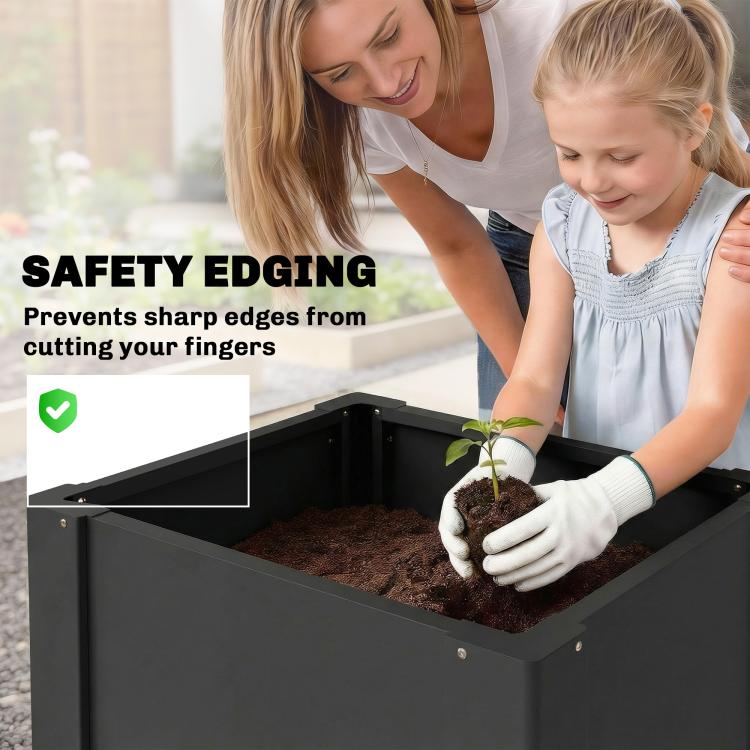 Black raised garden bed planter box with safety-style edge and a person planting