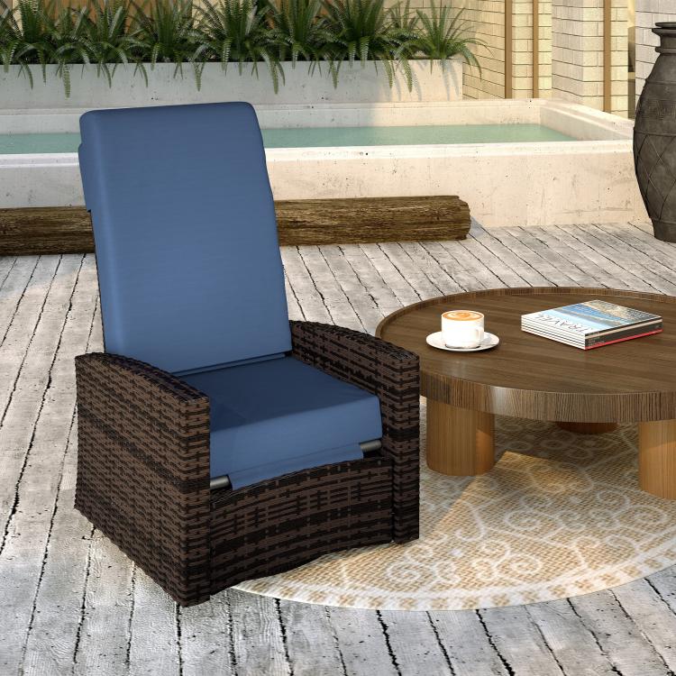 Outdoor wicker swivel recliner chair with dark brown arms and dark blue cushions, reclined with footrest