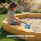 Yellow wooden bench seats around sand box with kids seated and playing.