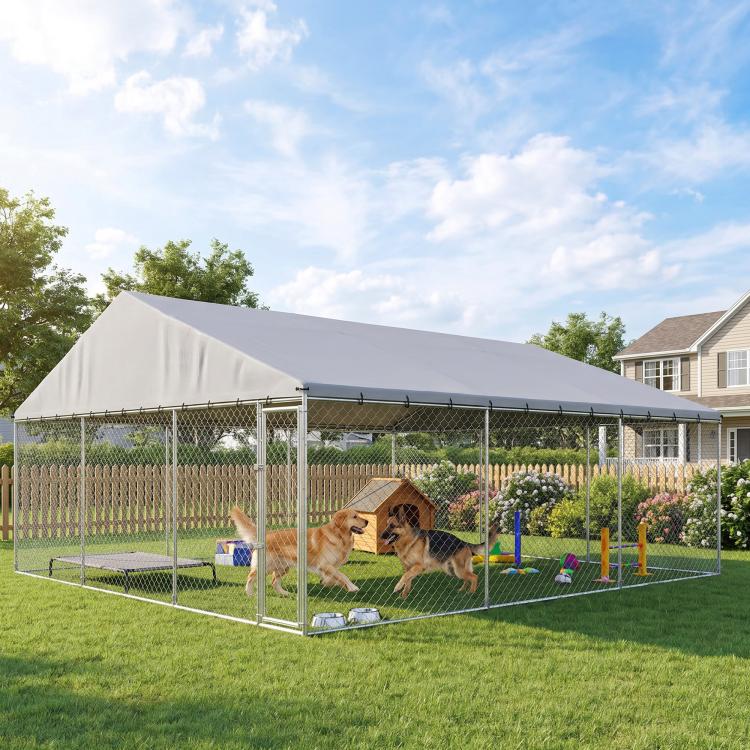 Outdoor chain-link dog run with gray roof and divided play area in backyard