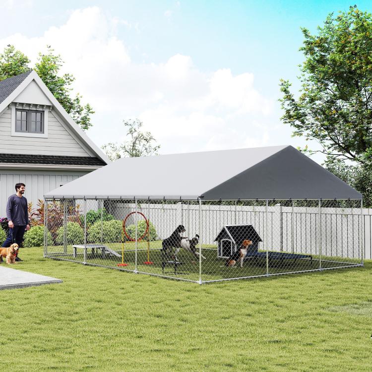 Outdoor dog kennel with chain-link fence and gray roof cover, side angle