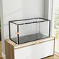 Acrylic pet cage with black frame on wood-and-white cabinet with clear walls