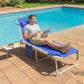 Blue folding chaise lounge chair with face hole and side table beside pool