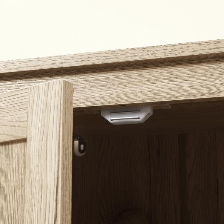 Natural wood cabinet door hinge with interior light above open storage space