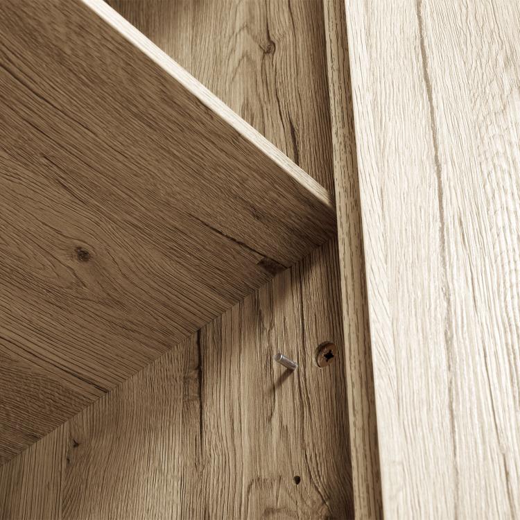 Close-up of natural wood cabinet corner with black knob and recessed joinery