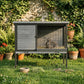 Outdoor wooden rabbit hutch with open wire front; rabbit sitting on mesh floor