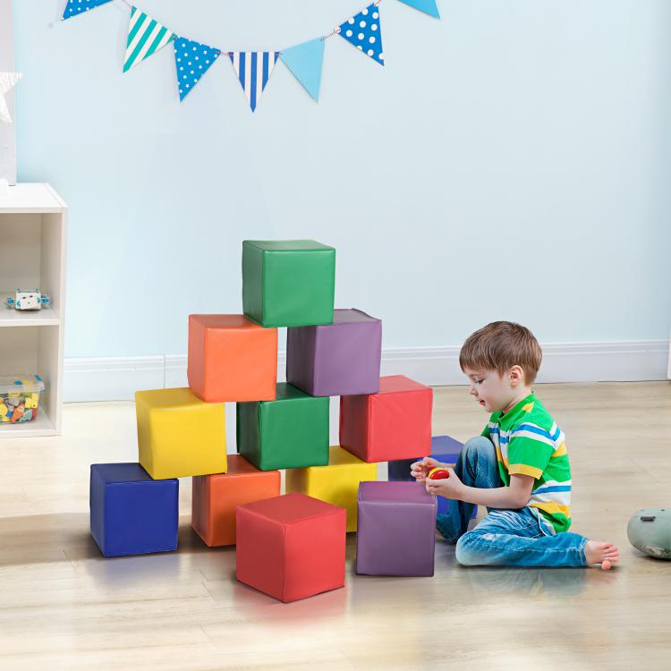 Colorful foam cube blocks stacked into a tower with a toddler playing nearby