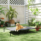 Gray elevated dog bed with black metal frame and mesh top, on outdoor grass