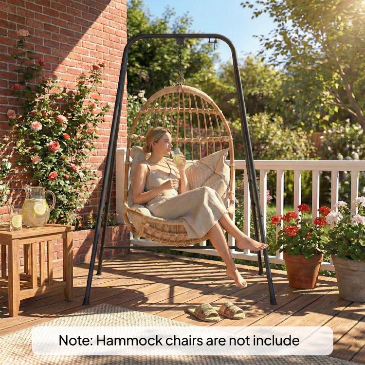 Black hammock chair stand with hanging hammock chair and a person seated on it
